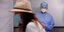 τουρίστρια με καπέλο για έλεγχο με rapid test και άνδρας νοσηλευτής με στολή