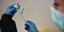 Νοσοκόμα κρατά φιαλίδιο του εμβολίου της AstraZeneca