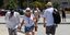 μάσκες με τουρίστες περπατούν στον δρόμο το καλοκαίρι