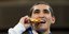 Ολυμπιονίκης δαγκώνειτ ο χρυσό μετάλλιο κατά την απονομή στους Ολυμπιακούς Αγώνες του Τόκιο