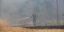 πυροσβέστης σβήνει με μάνικα τη φωτιά στη Βαρυμπόμπη