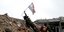 Στρατιώτης του συριακού καθεστώτος τοποθετεί την εθνική σημαία της Συρίας