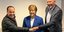 O Έλληνας εστιάτορας Αλέξης Βαϊου παραδίδει το κέρινο ομοίωμα της Άνγκελα Μέρκελ σε στέλεxος της CDU 