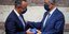 O Χρήστος Σταϊκούρας παραδίδει το στικάκι με τον προϋπολογισμό στον πρόεδρο της Βουλής, Κωνσταντίνο Τασούλα