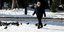 άνδρας περπατά σε δρόμο με χιόνια