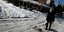 άνδρας με ψώνια στον δρόμο με χιόνια λόγω κακοκαιρίας Ελπίδα