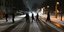 Ανθρωποι περπατούν βράδυ σε χιονισμένους δρόμους στη Γερμανία