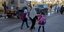 παιδιά με τσάντες περπατούν με τη μητέρα τους σε δρόμο στο Ισραήλ