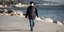 άνδρας με μάσκα περπατάει στην παραλία