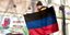 Δημοτικός υπάλληλος κρεμά τη σημαία της Λαϊκής Δημοκρατίας του Ντονέτσκ
