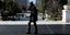 κοπέλα περπατάει στην Πλατεία Συντάγματος κρατώντας ένα ζεστό ρόφημα