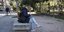 μια κοπέλα κάθεται σε παγκάκι στο κέντρο της αθήνας