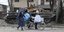 Άμαχοι περνούν μπροστά από κατεστραμμένο τανκ σε δρόμο της Μαριούπολης 