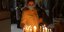 μεγάλη πέμπτη μια γυναίκα ανάβει κερί σε εκκλησία το Πάσχα
