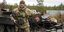 Ένας Ουκρανός στρατιώτης δείχνει ένα έμβλημα της επίλεκτης μονάδας των ρωσικών δυνάμεων κοντά σε κατεστραμμένα ρωσικά τανκς/ φωτογραφία AP