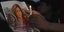 Παλαιστίνιοι κρατούν κερί και φωτογραφία στη μνήμη της δολοφονημένης δημοσιογράφου Σιρίν Αμπού Άκλεχ στη Δυτική Όχθη