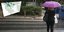 μια γυναίκα περπατά με ομπρέλα στη βροχή 