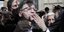 Ο Ζαν-Λυκ Μελανσόν κρατάει ένα κρίνο σε εκδήλωση για την πρωτομαγιά στο Παρίσι