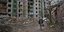 Άνδρας μπροστά σε κατεστραμμένη πολυκατοικία στο Τσερνίχιβ της Ουκρανίας