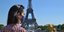 Γυναίκα με μάσκα μπροστά από τον πύργο του Άιφελ, στη Γαλλία