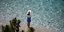 κοπέλα με καπέλο όρθια στη θάλασσα με καλό καιρό