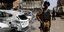 Στρατιώτης της Μπουρκίνα Φάσο μπροστά σε καμμένα αυτοκίνητα 