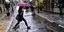 Γυναίκα με ομπρέλα στην ισχυρή βροχή που έπληξε την Αθήνα 