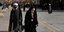 Μια γυναίκα και ένας κληρικός περπατούν στην πόλη Κομ του Ιράν