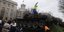 Ανδρας ανεβαίνει πάνω σε άρμα μάχης παρκαρισμένο έξω από την πρεσβεία της Ρωσίας