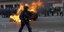 Αστυνομικός περπατά δίπλα από φωτιά σε κάδο