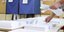 εκλογές 2023 / ένα μέλος της εφορευτικής επιτροπής τακτοποιεί ψηφοδέλτια σε πάγκο 