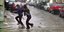 Δυο νεαρές γυναίκες διασχίζουν ένα πλημμυρισμένο δρόμο κατά τη διάρκεια νεροποντής στην Αθήνα