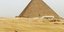Ένας άνδρας περνά από την πυραμίδα του Khufu στο σύμπλεγμα πυραμίδων της Γκίζας στην έρημο