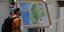 Άνδρας μεταφέρει τον νέο χάρτη της Βενεζουέλας με την επικράτεια Essequibo, μια μεγάλη έκταση γης που διαχειρίζεται και ελέγχεται από τη Γουιάνα αλλά διεκδικείται από τη Βενεζουέλα