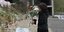 Γυναίκα αφήνει λουλούδια στο σημείο της τραγωδίας των Τεμπών