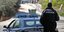αστυνομικός πίσω από περιπολικό σε ανοιχτό δρόμο στην επαρχία