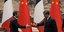 Ο Γάλλος πρόεδρος Εμανουέλ Μακρόν (αριστερά) ανταλλάσσει χειραψία με τον Κινέζο πρόεδρο Σι Τζινπίνγκ