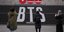 Πεζοί σταματούν για να τραβήξουν φωτογραφίες στα τεράστια γράμματα του συγκροτήματος K-pop BTS στο κέντρο της Σεούλ – Φωτ: ΑΡ