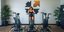 νεα γυναίκα σε χώρο με 3 στατικά ποδήλατα κάνει άσκηση