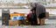 Γυναίκα μαζεύει τα απομεινάρια από τη λαϊκή /Φωτογραφία Αρχείου: Intime News