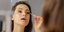 Mια γυναίκα μακιγιάρεται στον καθρέπτη/ Φωτογραφία: Shutterstock