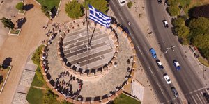 Οι πρόσφυγες μαζί με άλλους επισκέπτες σχηματίζουν το σύμβολο της ειρήνης πάνω στο Λευκό Πύργο