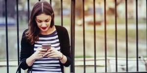 Μια γυναίκα κοιτάει το κινητό της