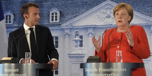 Στιγμιότυπο από την κοινή συνέντευξη Τύπου Μέρκελ- Μακρόν (Φωτογραφία: AP/ Jens Meyer)