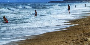 Κολυμβητές σε παραλία με κύματα/Φωτογραφία:Eurokinissi/Γιώργος Κονταρίνης