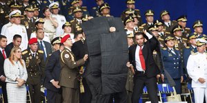 Φρουροί του Μαδούρο τον καλύπτουν με αλεξίσφαιρα (Φωτογραφία: AP/ Xinhua)
