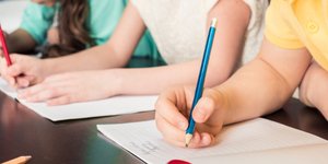 Μαθητές γράφουν στο τετράδιο