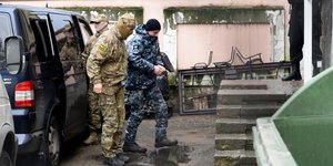 Ρώσος πράκτορας της FSB οδηγεί συλληφθέντα Ουκρανό ναυτικό σε δικαστήριο στη Συμφερόπολη (Φωτογραφία: ΑΡ)