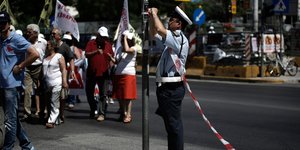 Αστυνομικός της Τροχαίας τοποθετεί την ειδική κορδέλα διακοπής κυκλοφορίας / Φωτογραφία: SOOC