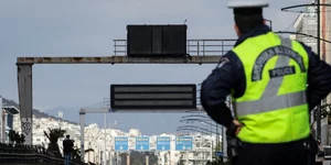 Αστυνομικός κοιτάζει την ετοιμόρροπη πινακίδα στη λεωφόρο Συγγρού / Φωτογραφία: Eurokinissi/Γιάννης Παπαδόπουλος 